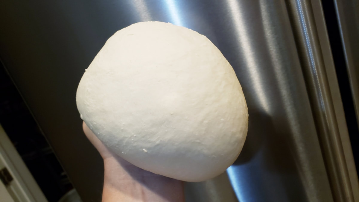 A smooth ball of freshly kneaded pizza dough