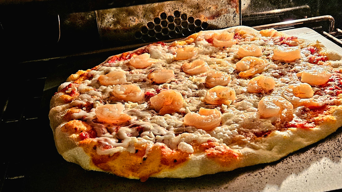 shrimp and garlic pizza baking in a home oven